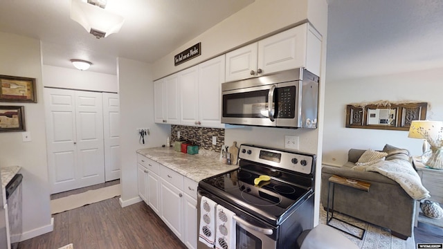 kitchen with dark wood-style flooring, tasteful backsplash, appliances with stainless steel finishes, white cabinetry, and baseboards