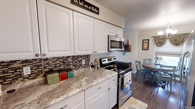 kitchen with appliances with stainless steel finishes, white cabinets, and decorative backsplash