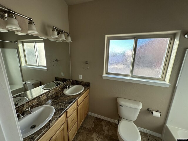 full bathroom with toilet, baseboards, and a sink