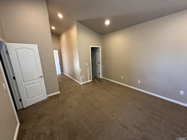 unfurnished room with high vaulted ceiling, recessed lighting, dark carpet, and baseboards