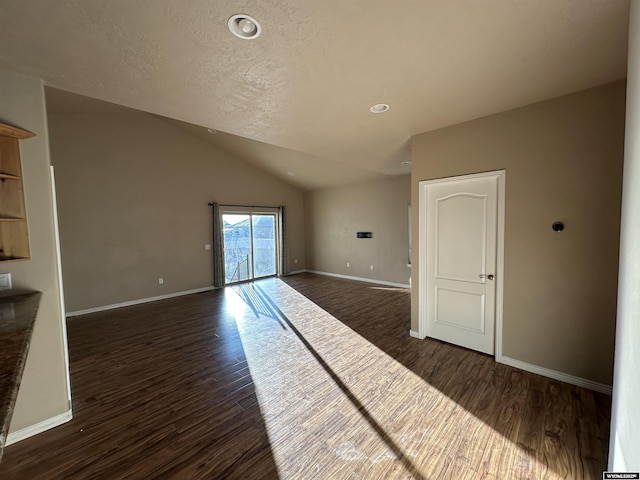 unfurnished living room with lofted ceiling, dark wood-style floors, and baseboards