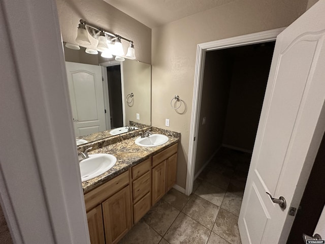 full bathroom featuring double vanity, a sink, and tile patterned floors