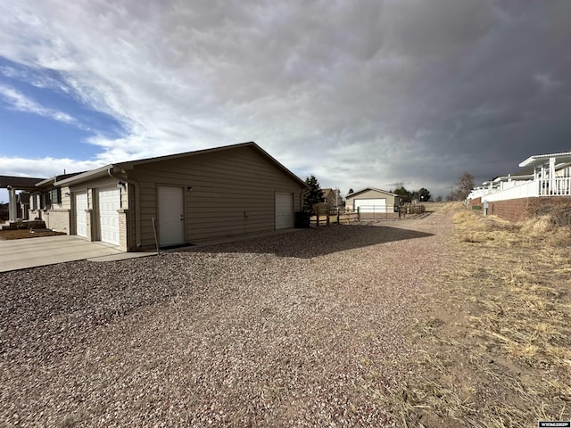 view of home's exterior with an outbuilding, fence, and a detached garage