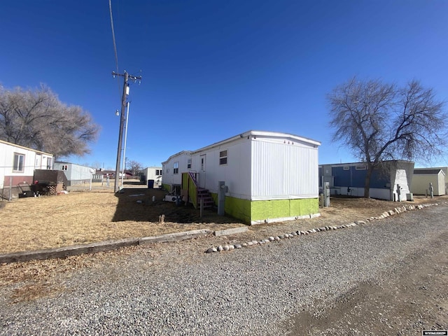 view of side of home featuring gravel driveway