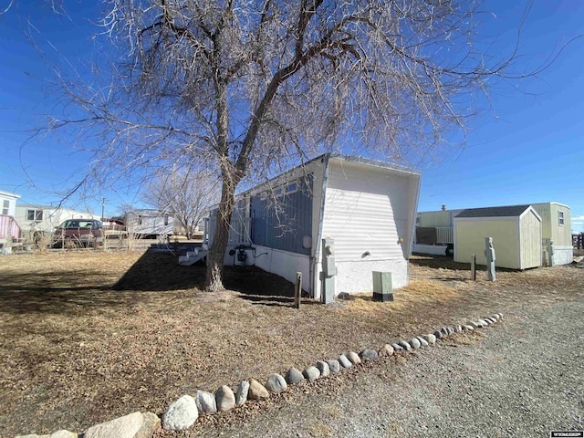 view of side of home featuring a shed and an outdoor structure