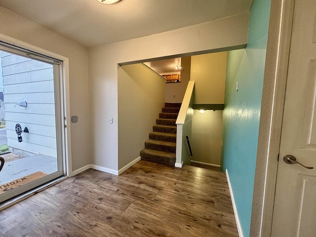 interior space with stairs, baseboards, and wood finished floors