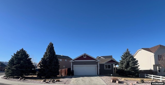 view of front of house with a garage, driveway, and fence