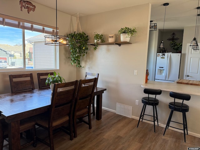 dining space featuring baseboards, visible vents, and wood finished floors