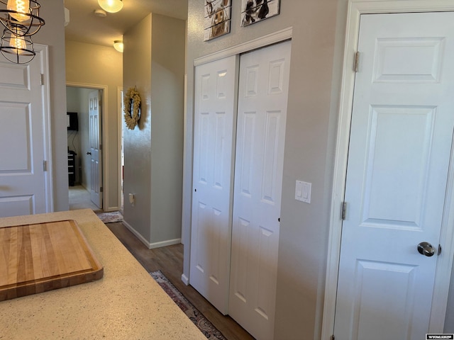 hall featuring baseboards and dark wood-style flooring