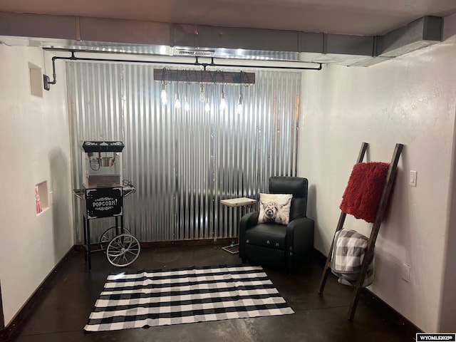 sitting room with concrete floors and baseboards