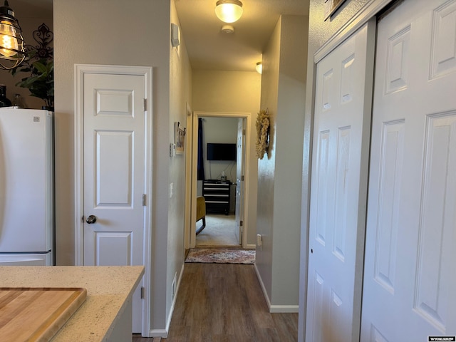 corridor with baseboards and dark wood-style flooring