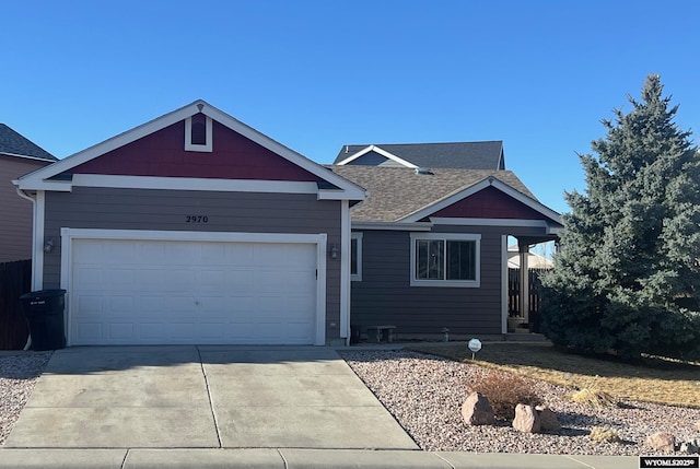 view of front of home featuring driveway, a shingled roof, and an attached garage