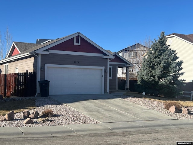 ranch-style house featuring a garage, fence, and concrete driveway