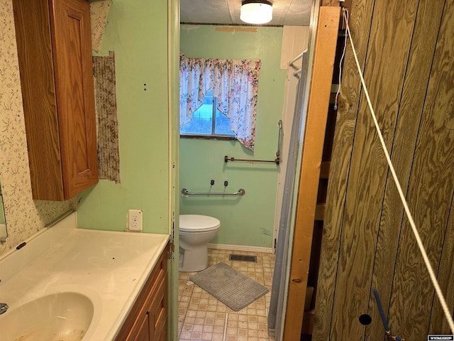 full bathroom with toilet, vanity, baseboards, visible vents, and tile patterned floors