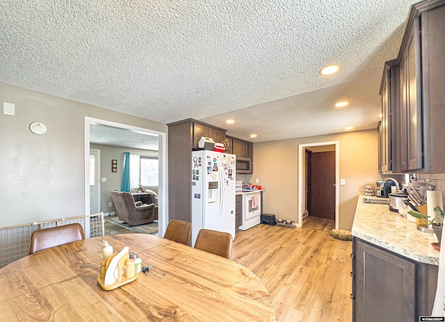 dining room featuring recessed lighting, a textured ceiling, and light wood-style flooring