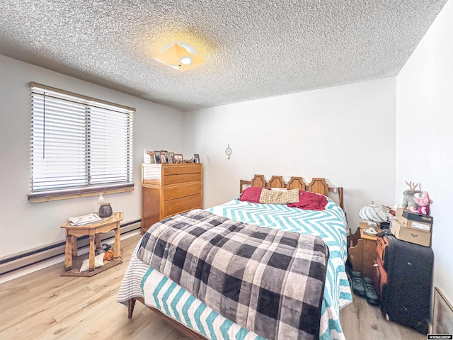 bedroom featuring light wood-style flooring, a baseboard radiator, and a textured ceiling