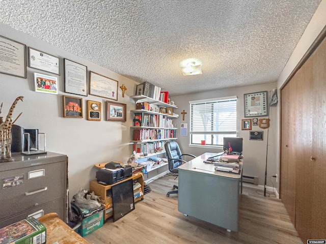 office area featuring wood finished floors, a baseboard radiator, and a textured ceiling