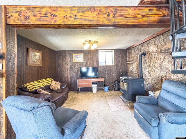 living room with light colored carpet, a textured ceiling, and a wood stove