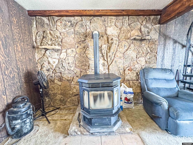 room details with beam ceiling, a wood stove, and a textured ceiling