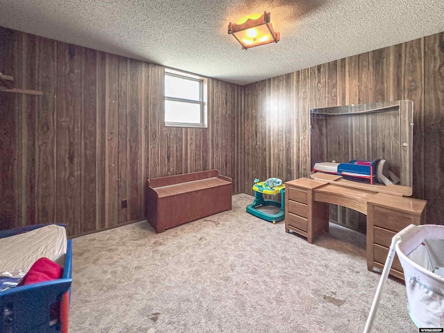 carpeted bedroom with wood walls and a textured ceiling