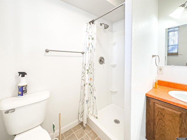 bathroom with tile patterned flooring, baseboards, toilet, a stall shower, and vanity