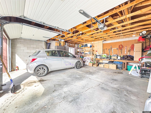 garage featuring a garage door opener and concrete block wall