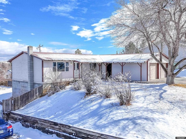 view of front of home with metal roof, a garage, and a chimney