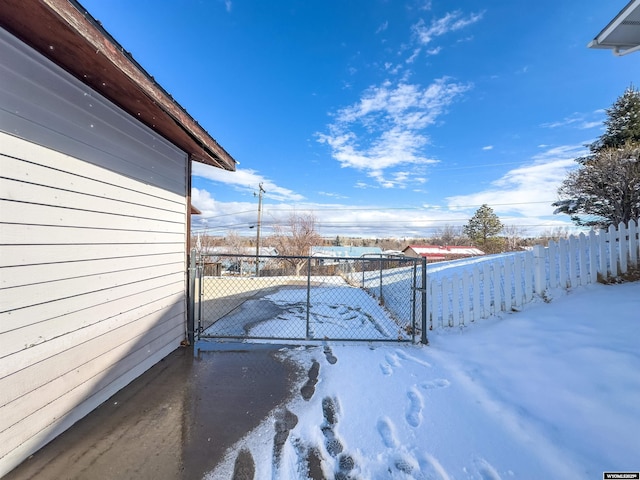 snowy yard with fence and a gate