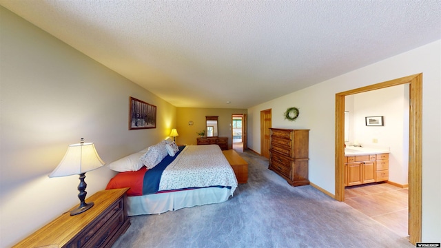 bedroom featuring light carpet, connected bathroom, baseboards, and a textured ceiling