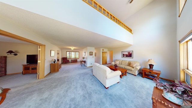 carpeted living area featuring a towering ceiling and baseboards