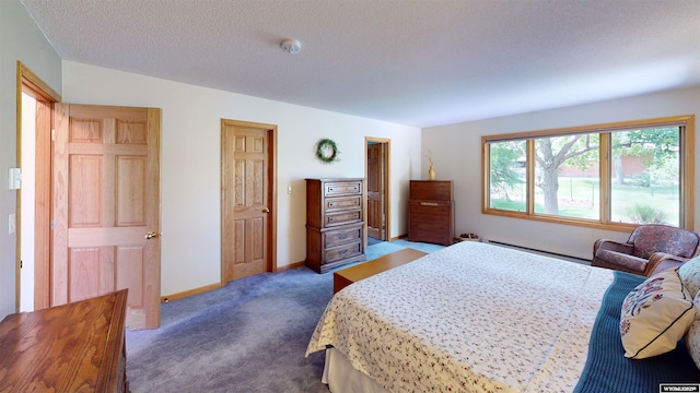 bedroom with a textured ceiling, baseboard heating, dark carpet, and baseboards