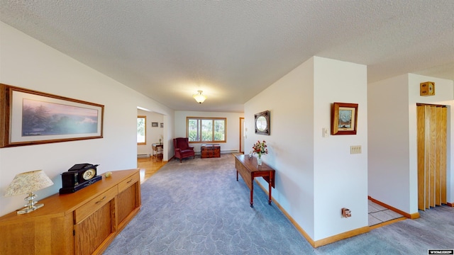 living room with light carpet, a textured ceiling, and baseboards