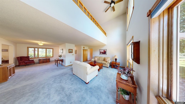 living room with ceiling fan, baseboards, and light colored carpet