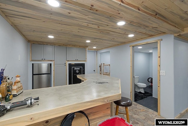 kitchen with freestanding refrigerator, wooden ceiling, gray cabinetry, and recessed lighting