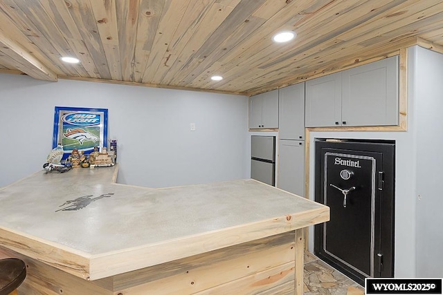 kitchen with recessed lighting, light countertops, wood ceiling, stainless steel fridge, and a peninsula