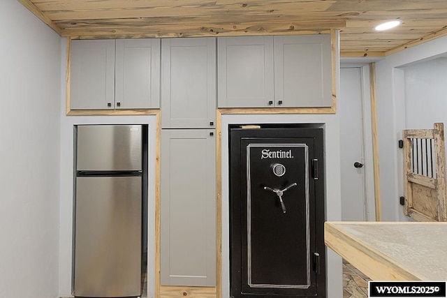 kitchen featuring wood ceiling, light countertops, and freestanding refrigerator