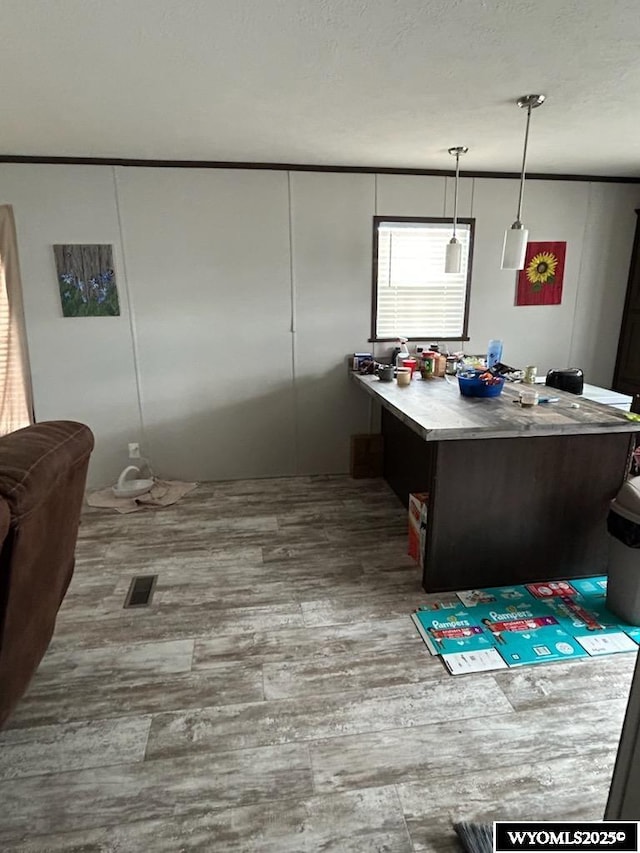 interior space with visible vents, a textured ceiling, and wood finished floors