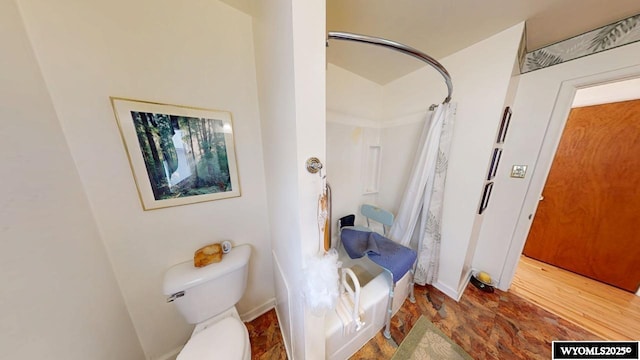 full bathroom featuring toilet and shower / bath combo with shower curtain