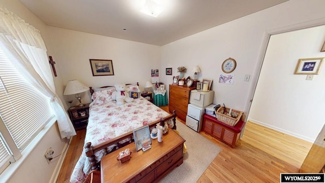 bedroom with light wood-type flooring and baseboards