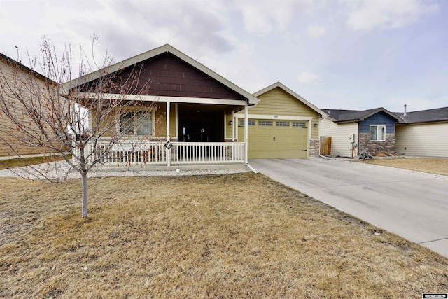 ranch-style house featuring covered porch, concrete driveway, stone siding, and a garage