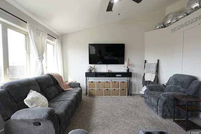 living room with a ceiling fan, lofted ceiling, and carpet flooring