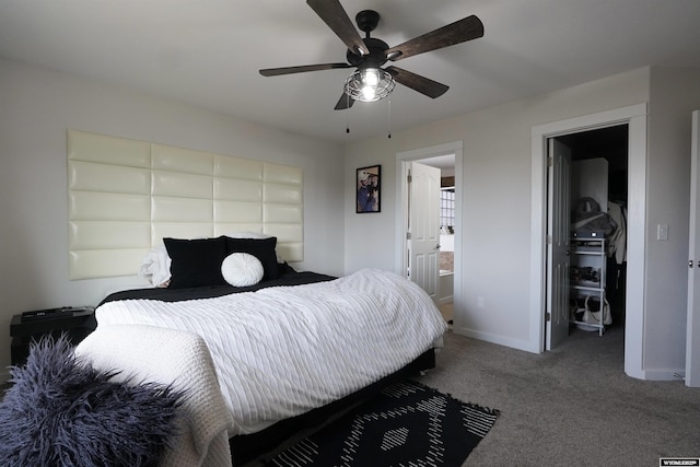 bedroom featuring baseboards, connected bathroom, ceiling fan, a walk in closet, and carpet floors