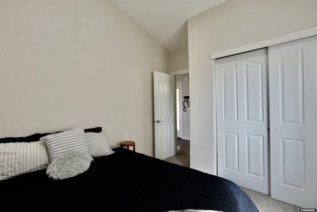 bedroom featuring carpet, vaulted ceiling, and a closet