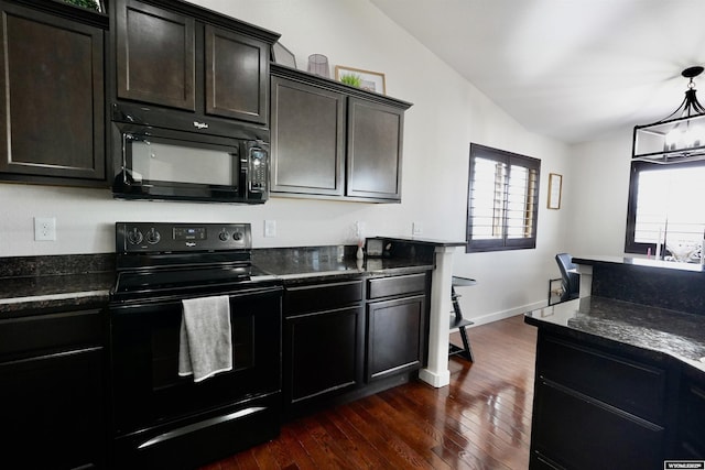 kitchen with dark stone countertops, dark wood-type flooring, vaulted ceiling, black appliances, and a chandelier