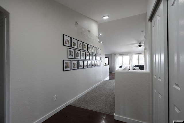 corridor with dark wood-style floors and baseboards