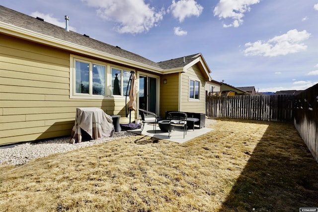 rear view of house featuring a fenced backyard and a patio