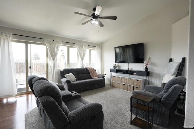 living area featuring ceiling fan, visible vents, vaulted ceiling, and wood finished floors