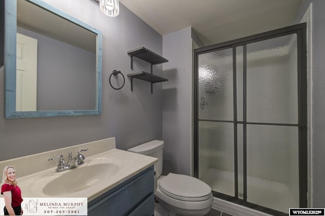 bathroom featuring a stall shower, vanity, and toilet