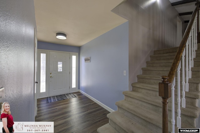 foyer entrance with stairway, baseboards, and wood finished floors