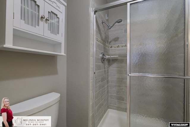 bathroom with a stall shower and toilet